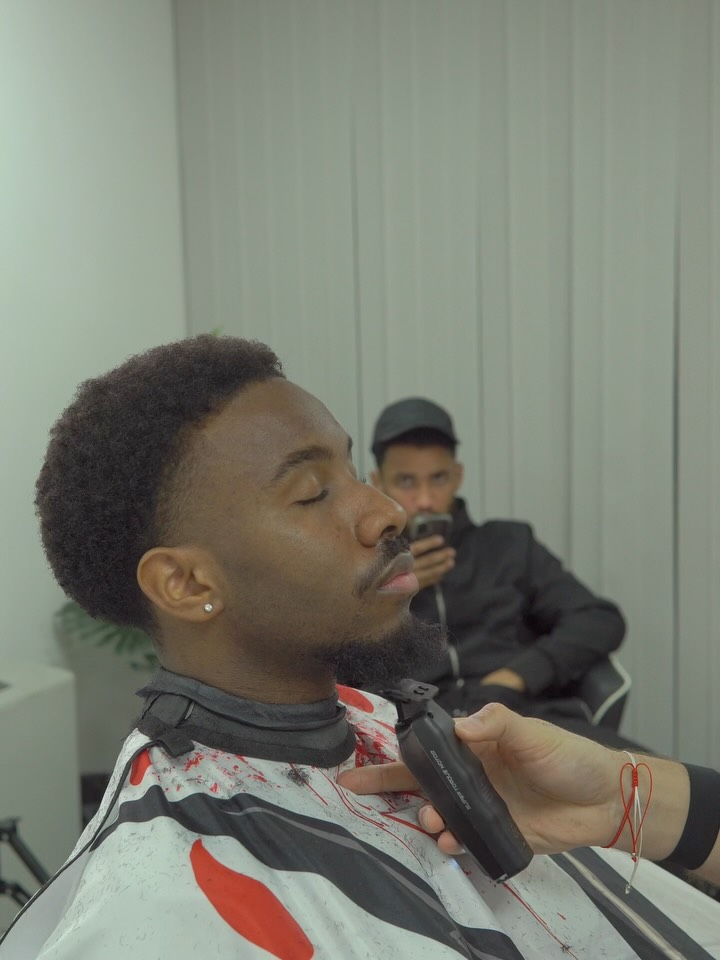 Barber detailing a client's beard with a trimmer
