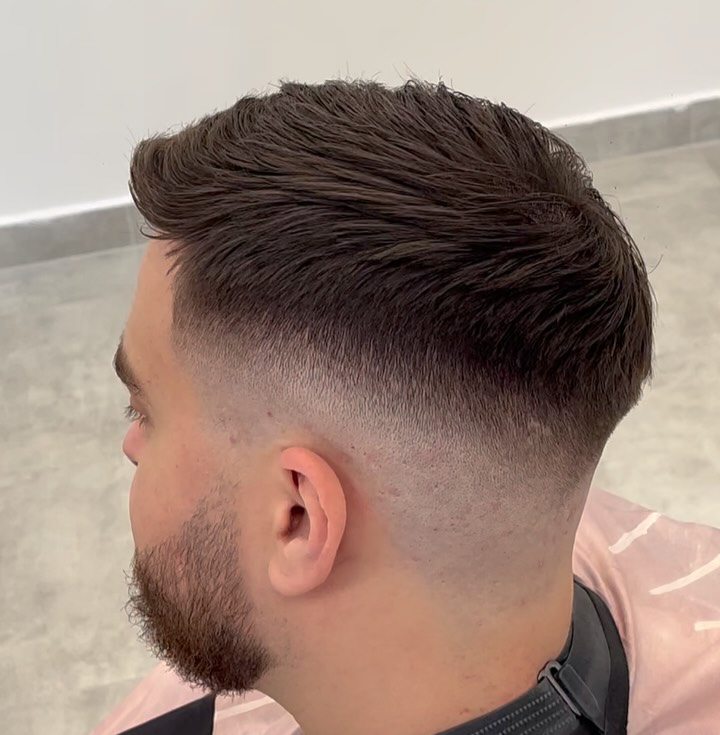 Textured top with a clean mid fade and beard blend